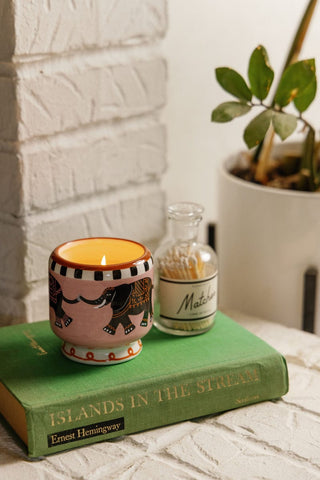 A Dopo Elephant candle lit on a stack of books