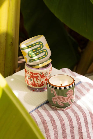 A Dopo Jungle candle styled on a striped cloth