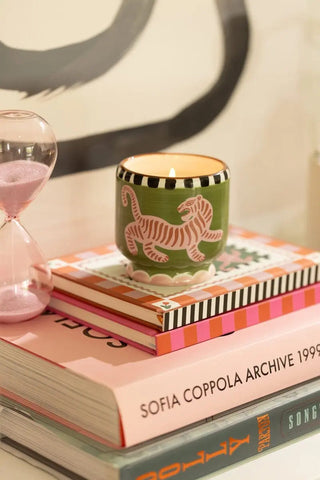 A Dopo Tiger candle styled on a stack of books