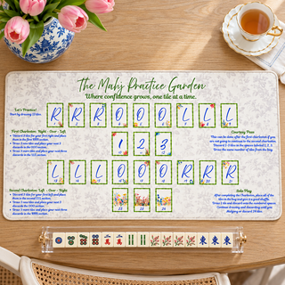 The Mahj Practice Garden mat on a wood table styled with pink tulips and a clear Mahjong rack